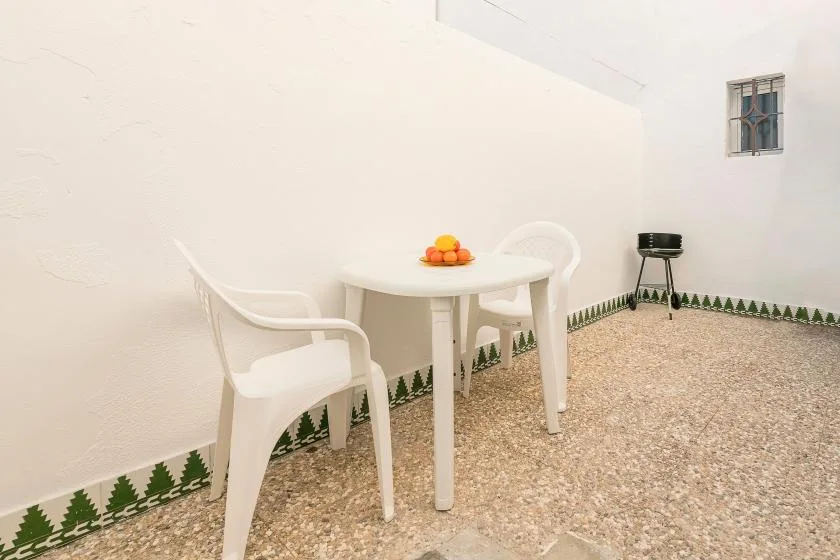 A small outdoor dining area with a white table and chairs.