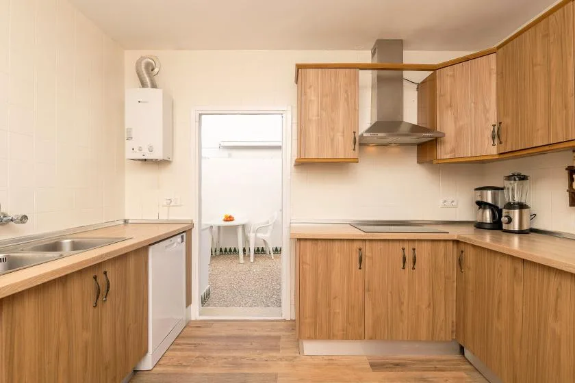 A kitchen with wood cabinets, countertops, and a range hood.