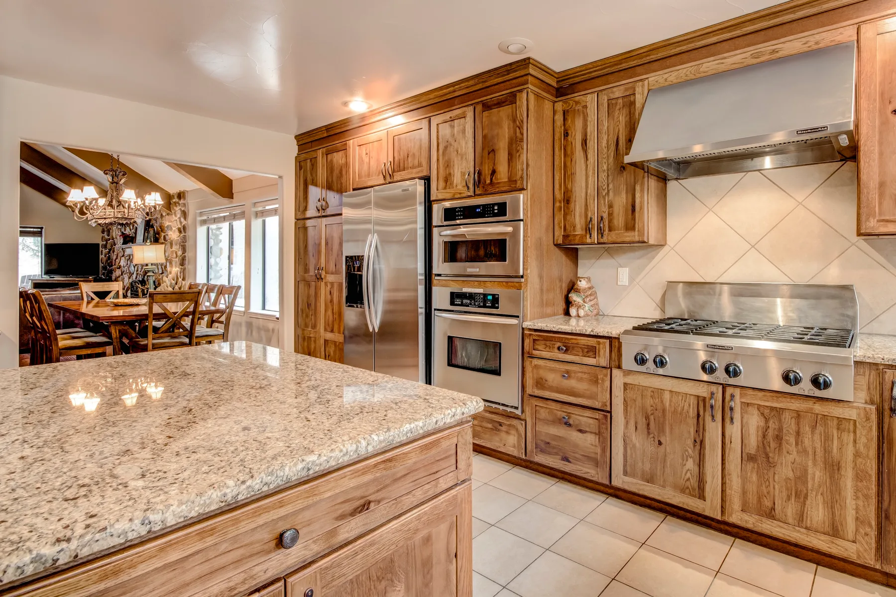 A kitchen with wood cabinetry, a large island, and stainless steel appliances.