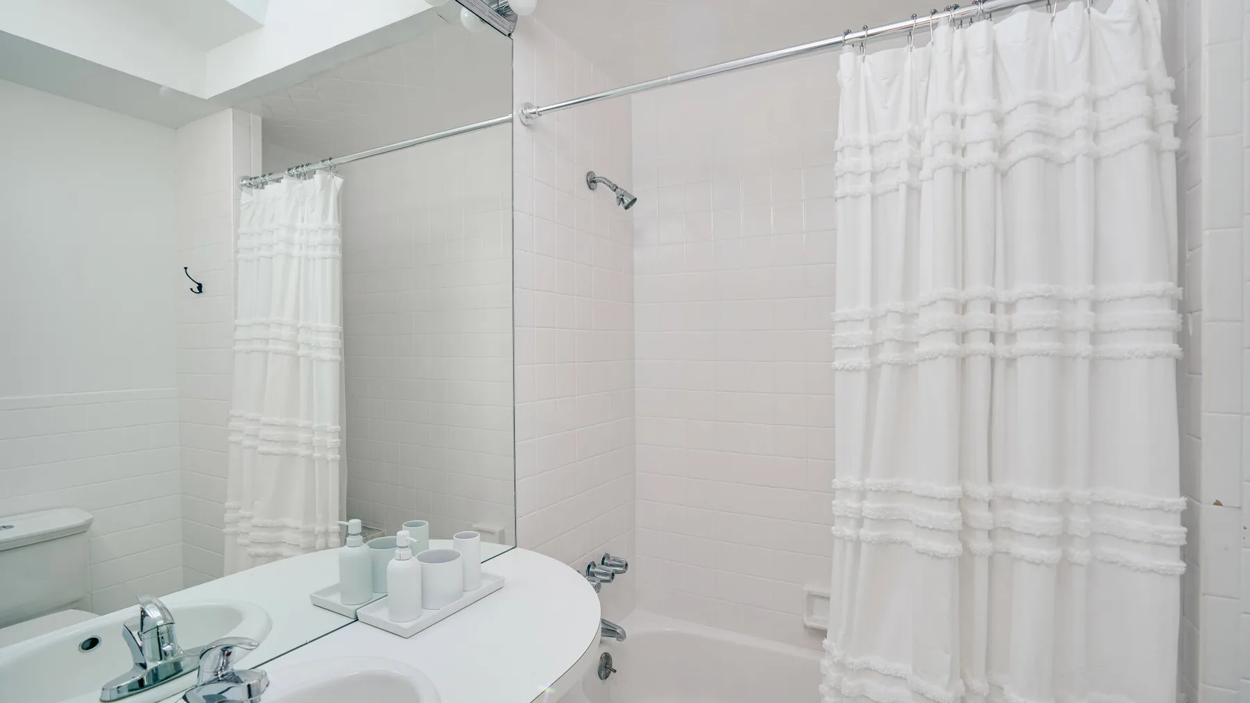 Un baño con una encimera curva junto al lavabo y una cortina de ducha.