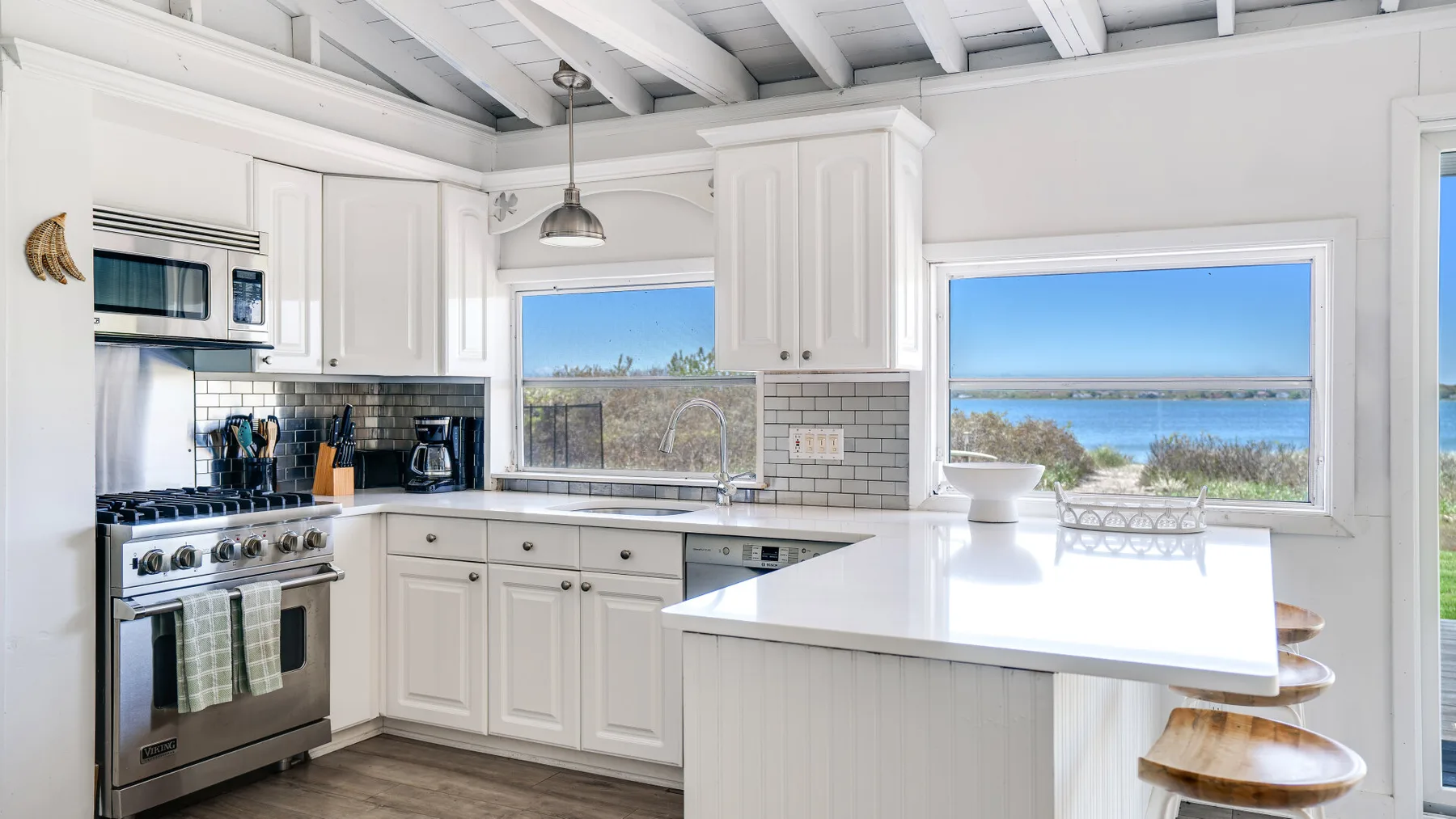 Una cocina luminosa con gabinetes blancos y una isla grande.