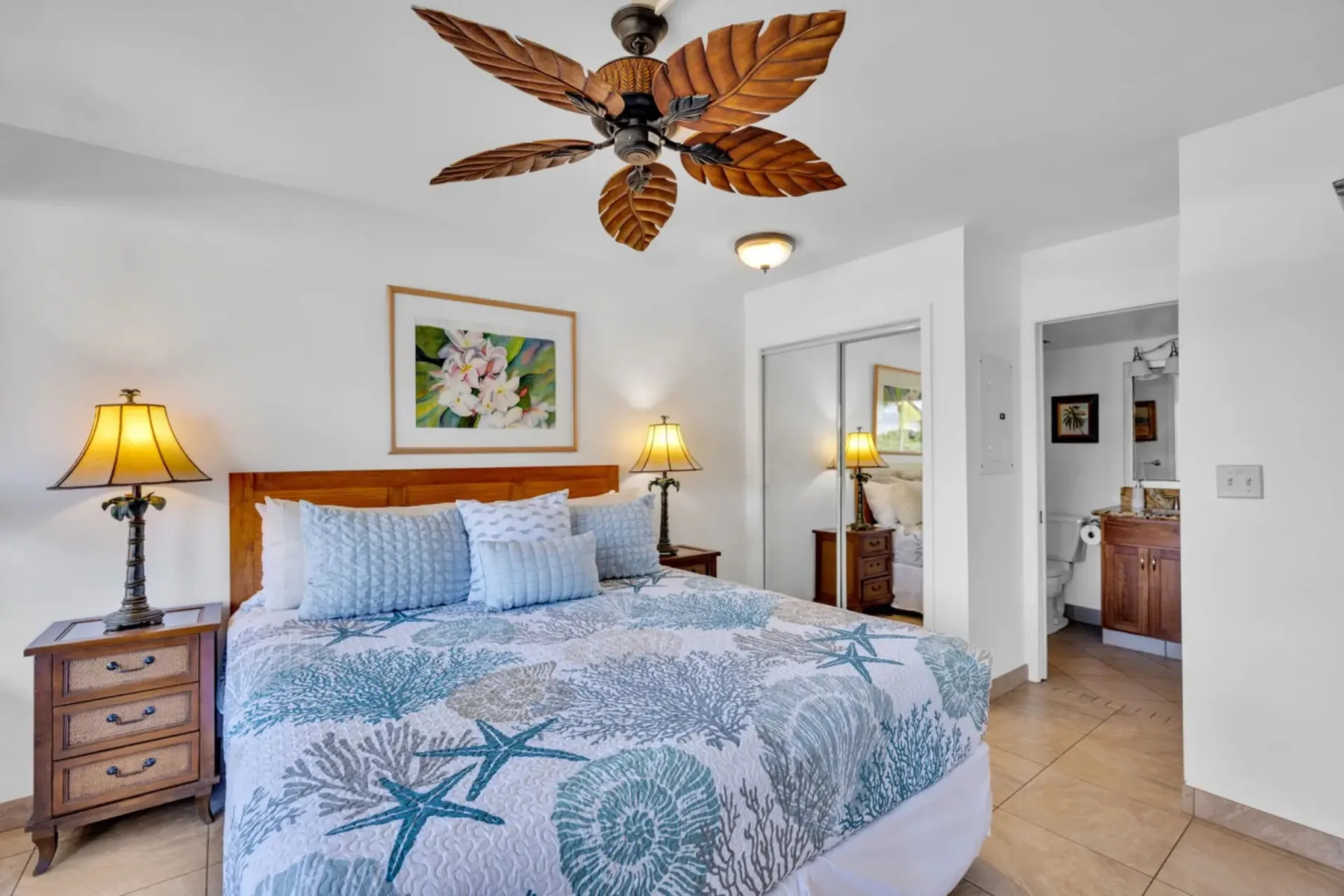 Un dormitorio con una cama grande cubierta con ropa de cama azul y blanca.