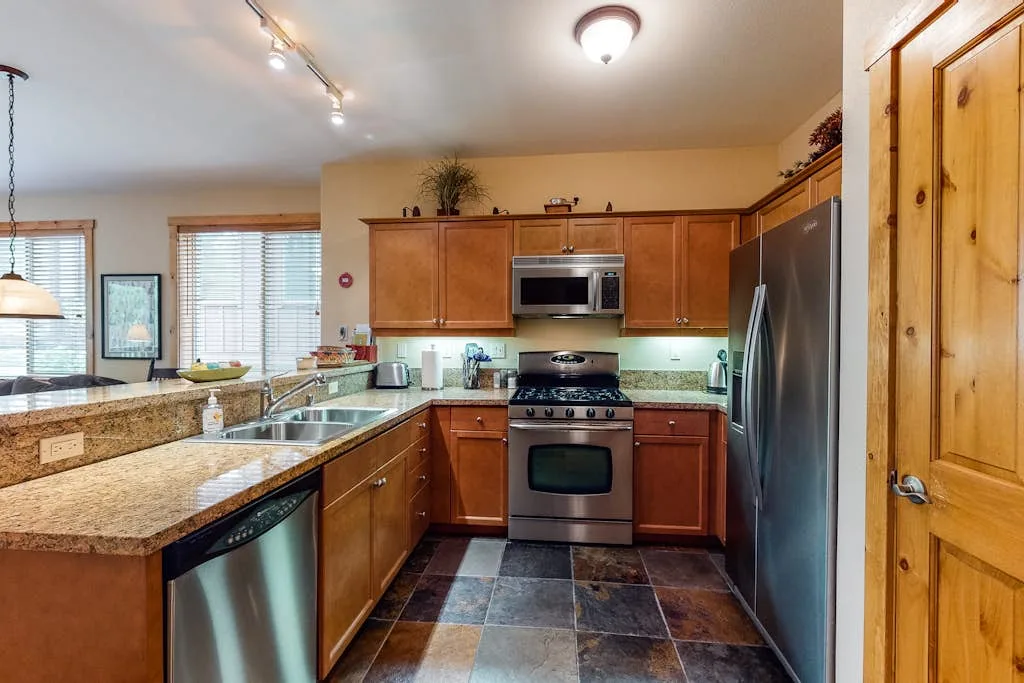 A kitchen with wooden cabinets, a stove, and a refrigerator.