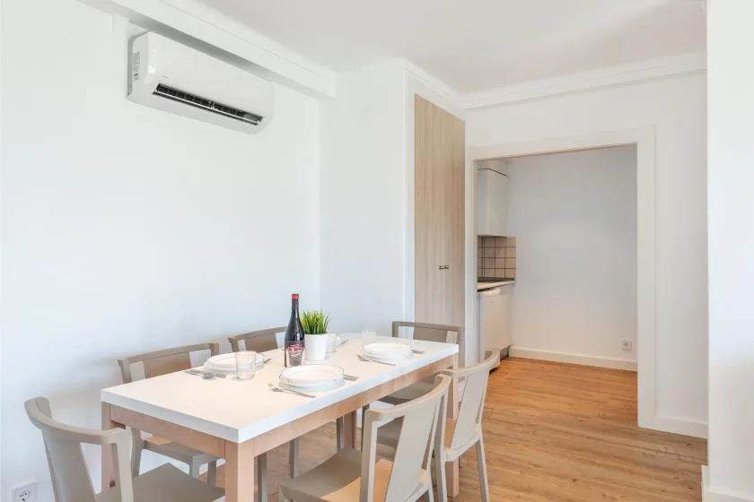 A dining area with a table and chairs beside an open doorway.