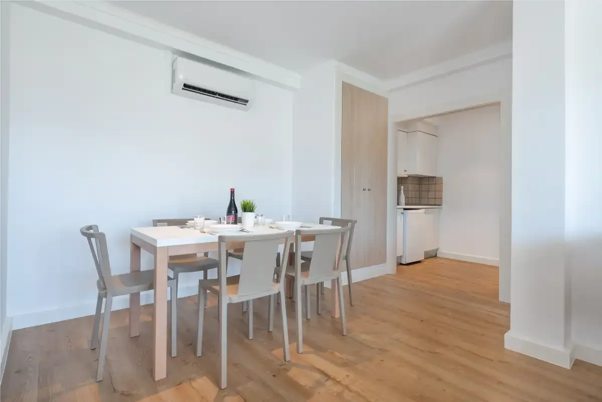 A dining area with a table and chairs beside an open kitchen.