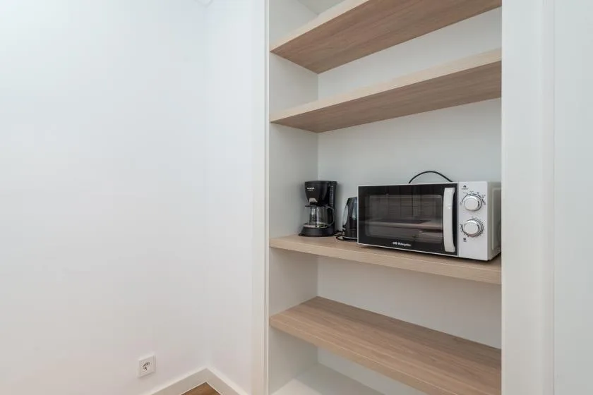 A built-in kitchenette shelf holds a coffee maker and countertop oven.