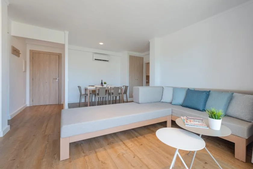 A bright living room with a sectional seating area and low tables.