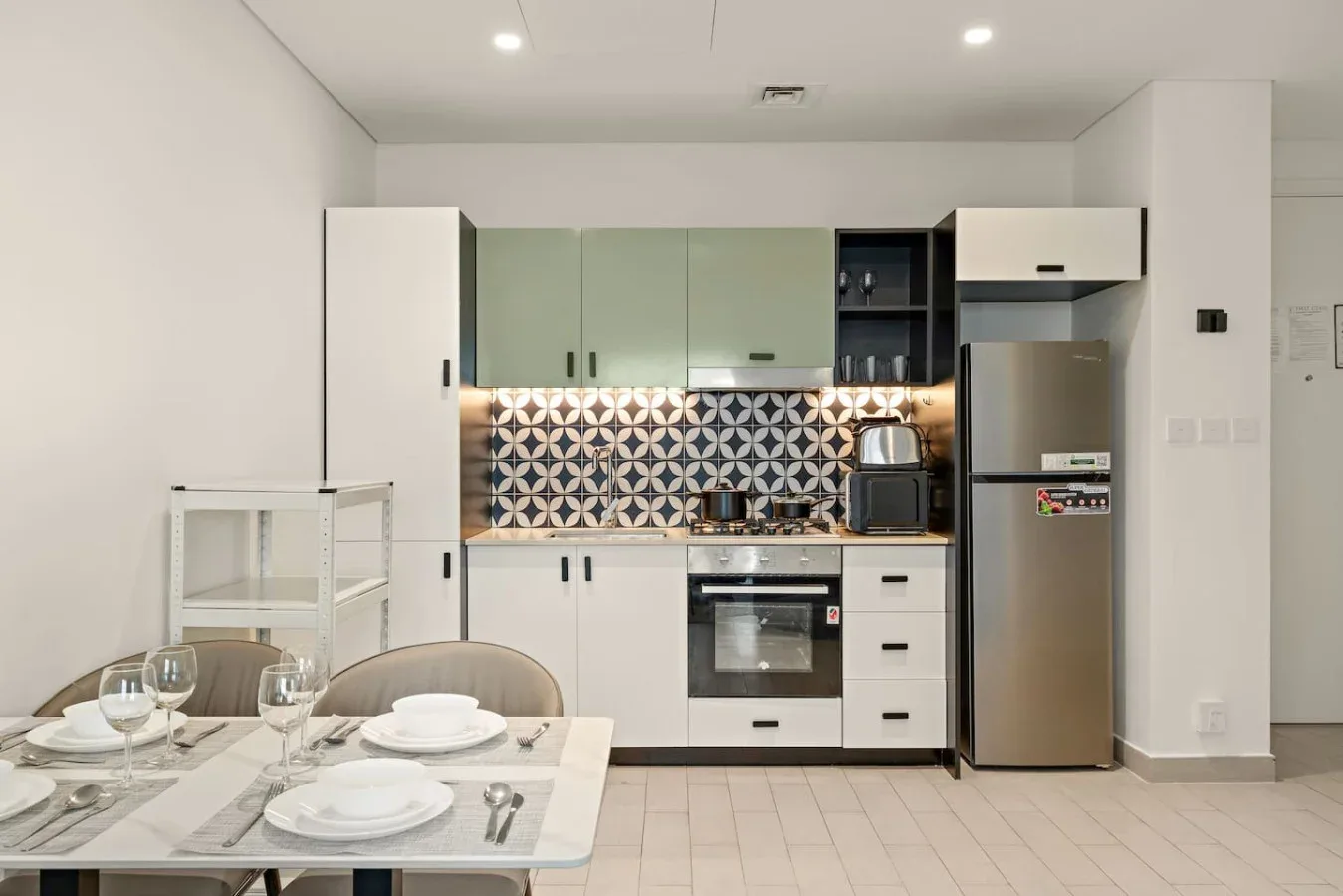 An open kitchen and dining area with patterned backsplash and a table set for a meal.