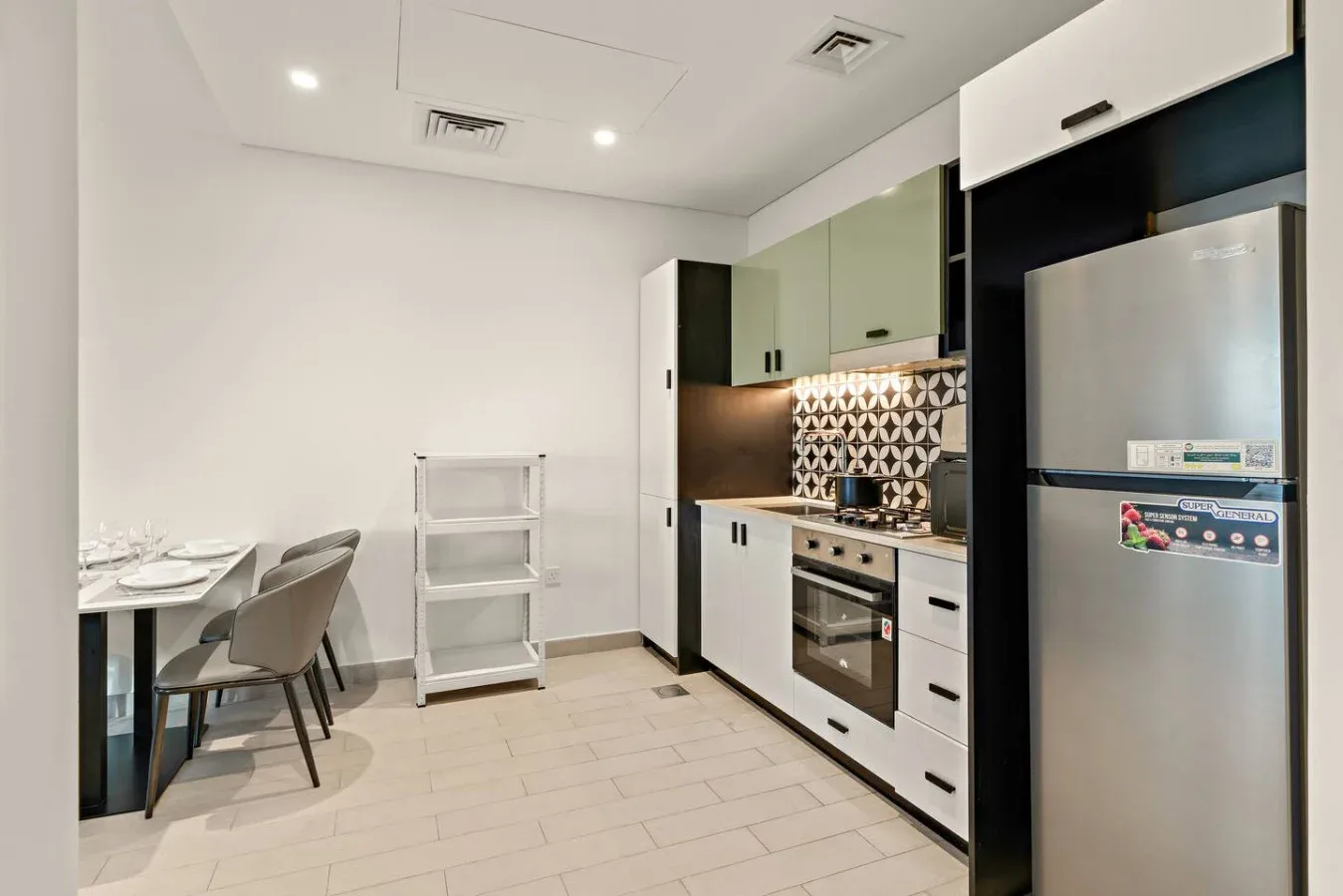 A modern kitchen with a dining table and chairs beside the cooking area.