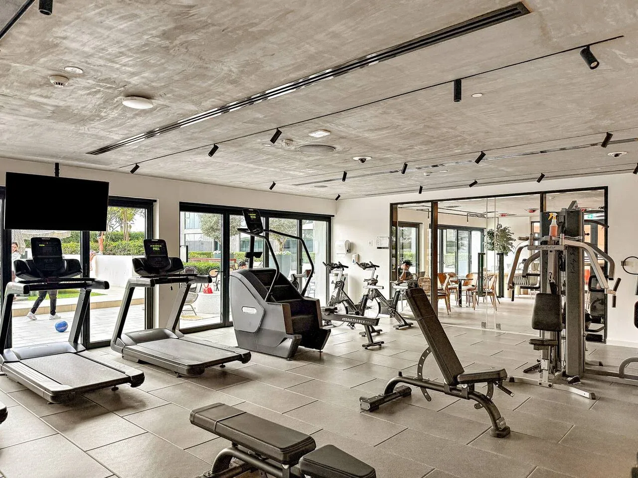 A gym with treadmills, exercise bikes, and strength-training equipment.