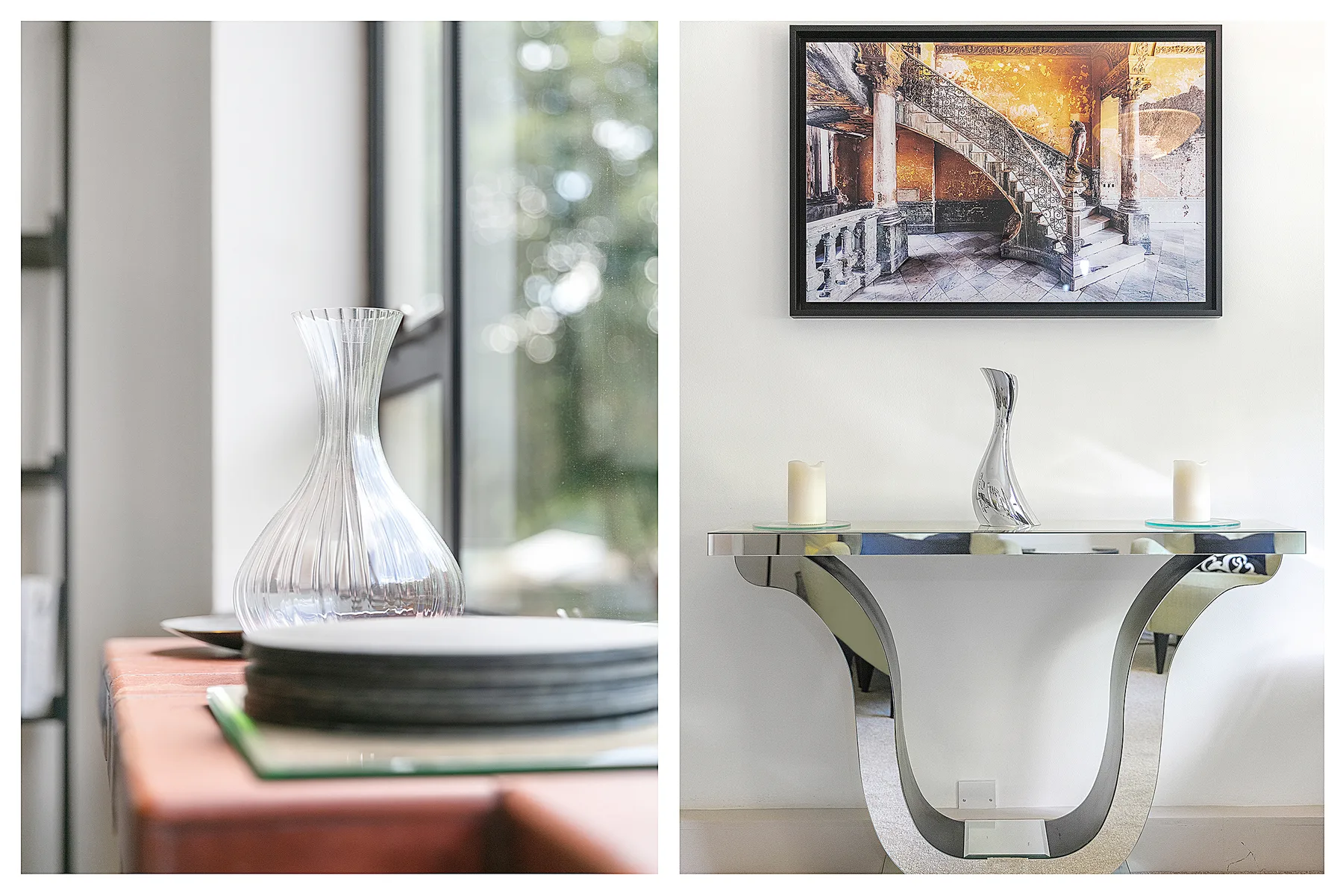 A decorative console table stands beneath framed artwork, with a vase and candles.