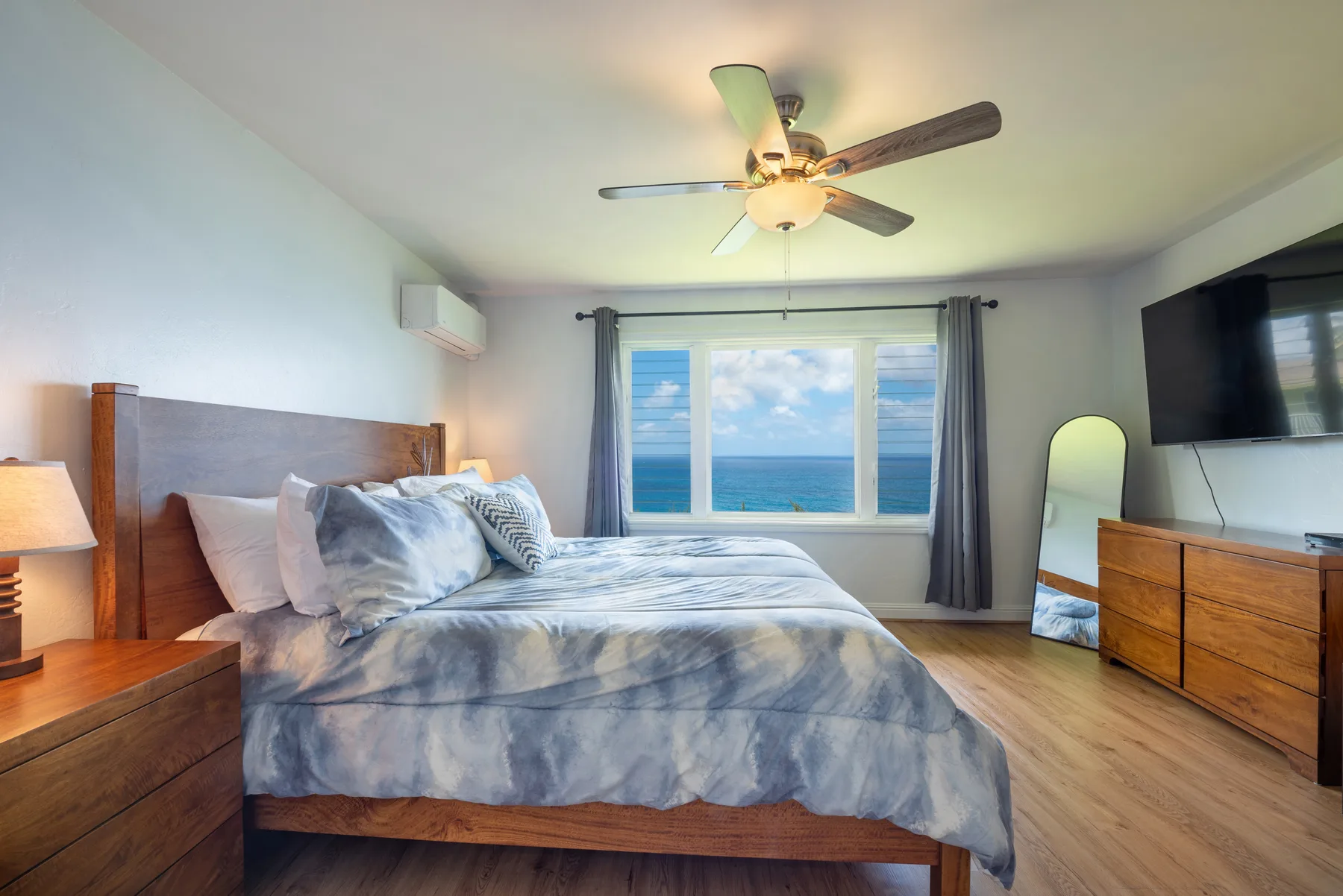 Un dormitorio con una cama frente a una ventana con vista al mar.