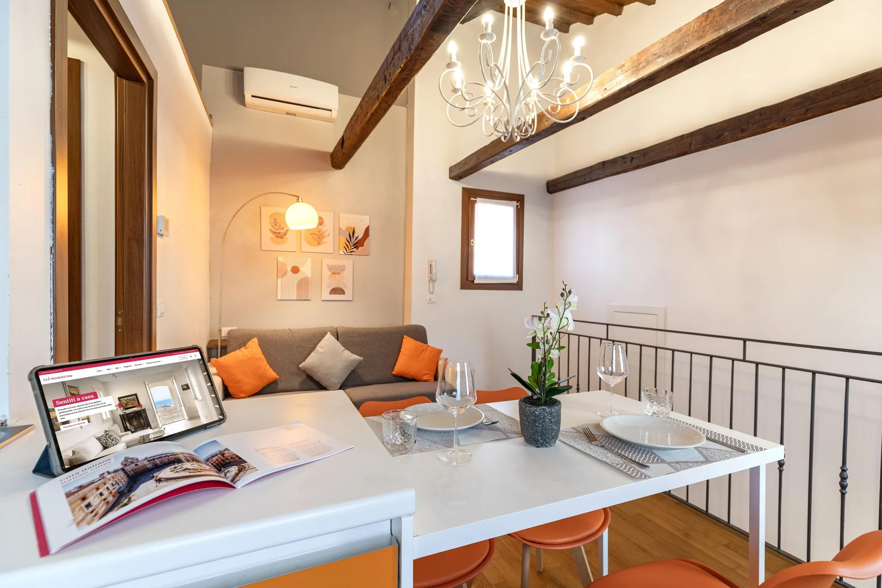 Comedor con una mesa, asientos y vigas de techo a la vista.