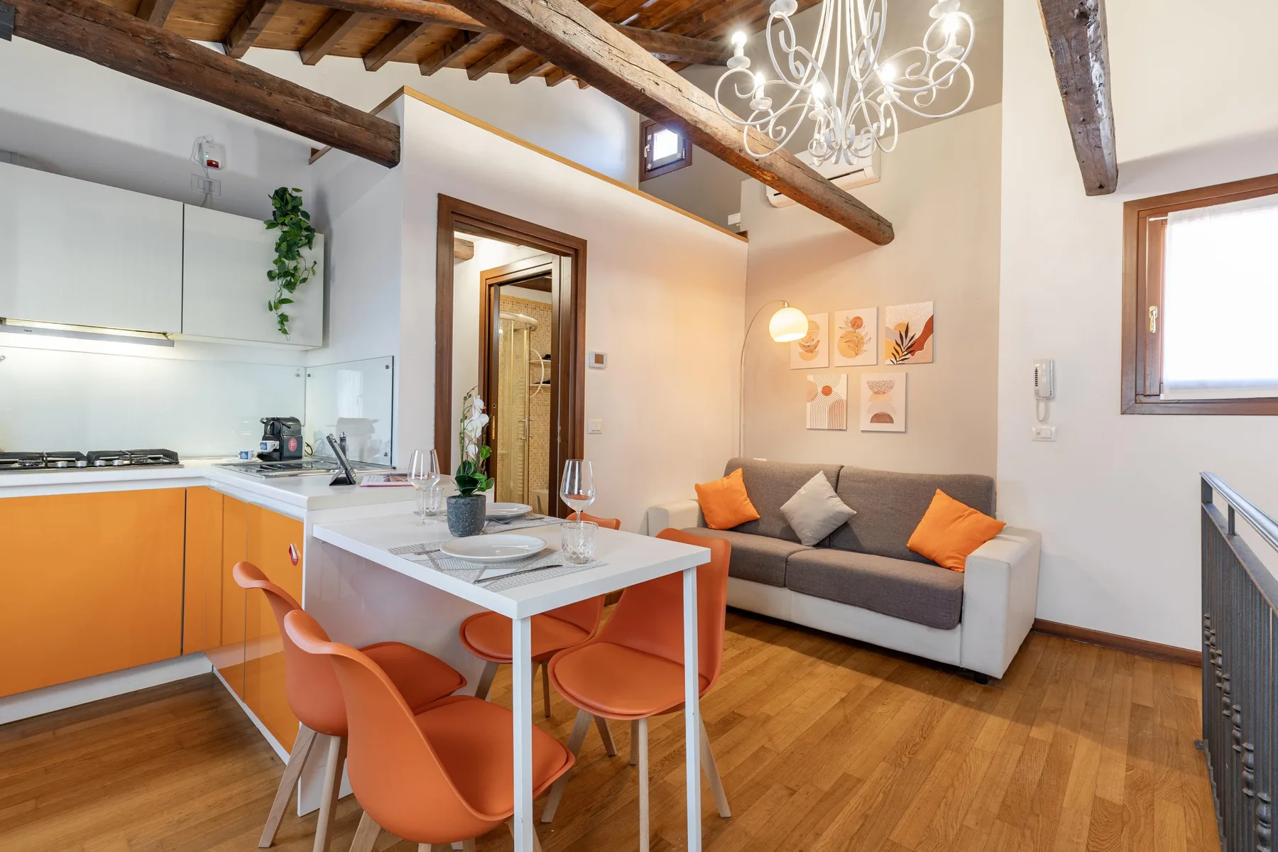 Una luminosa cocina abierta al salón, con mesa de comedor y sofá.