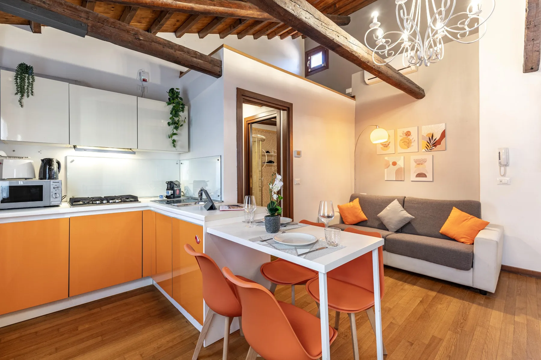 Una cocina abierta al salón, con mesa de comedor y sofá.