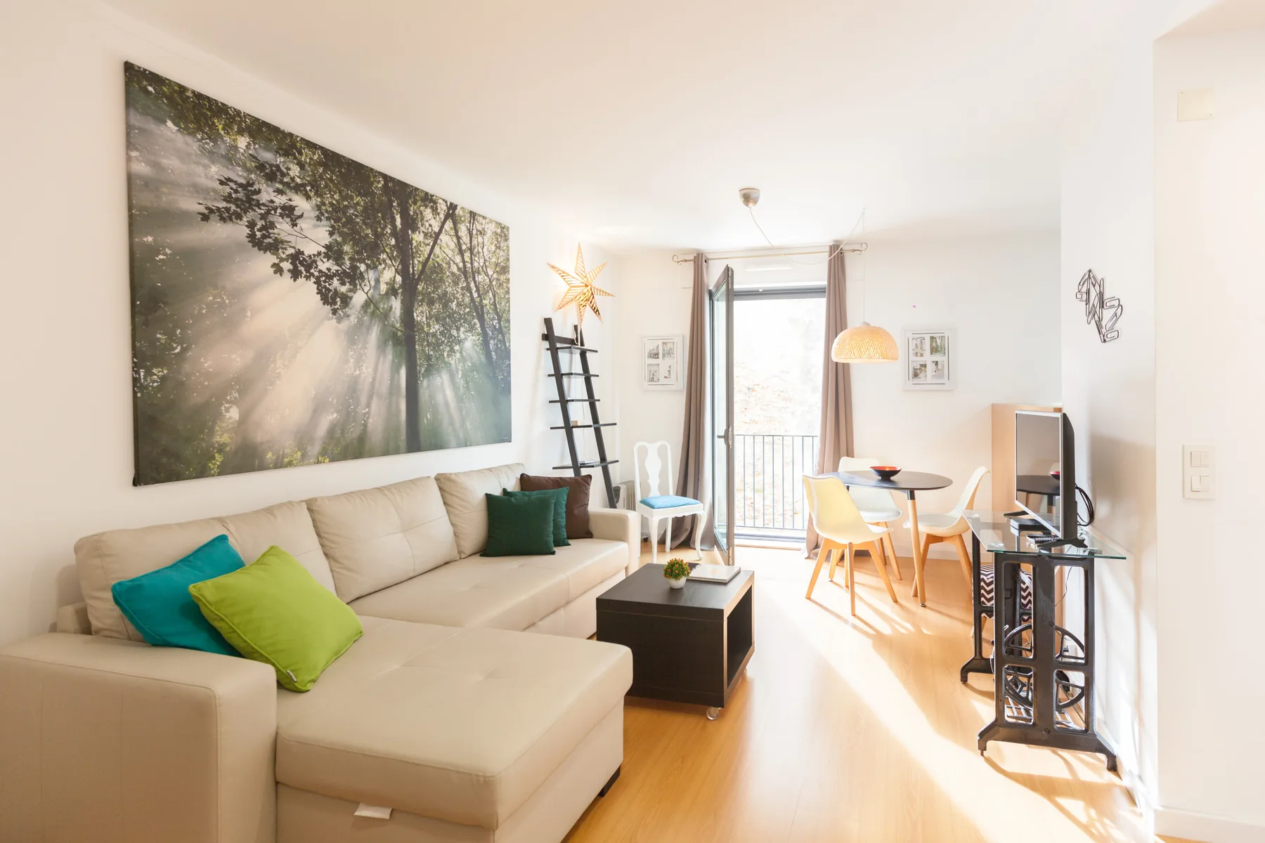 Una sala luminosa con una zona de asientos y una mesa de comedor.