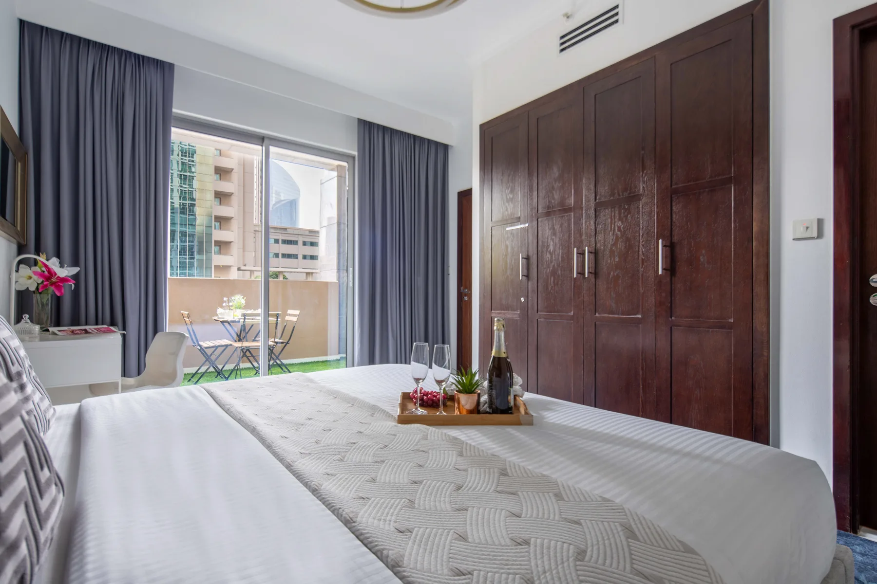 Un dormitorio con una cama bien tendida y armarios de madera oscura.