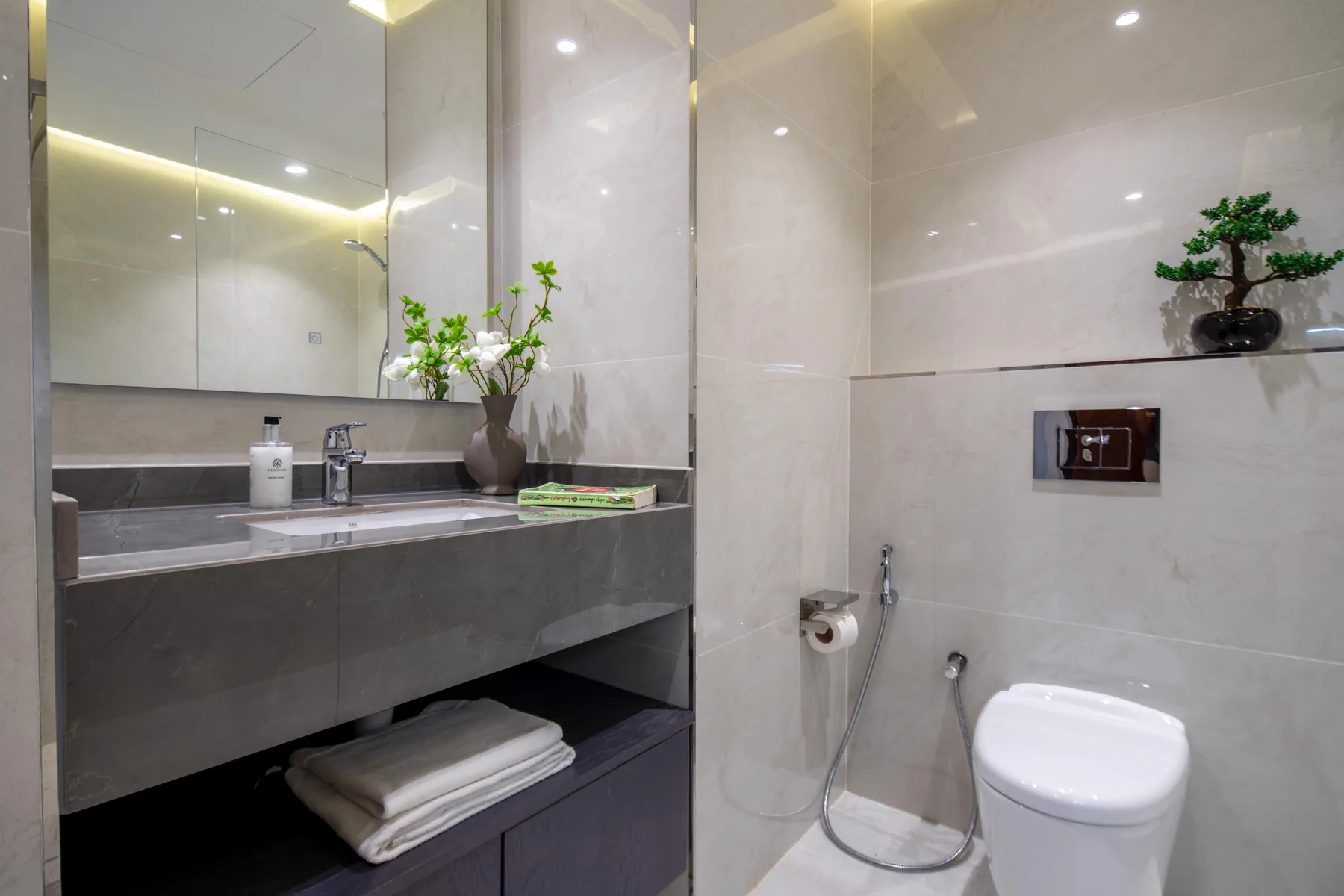 Un baño moderno con un tocador largo y un inodoro.