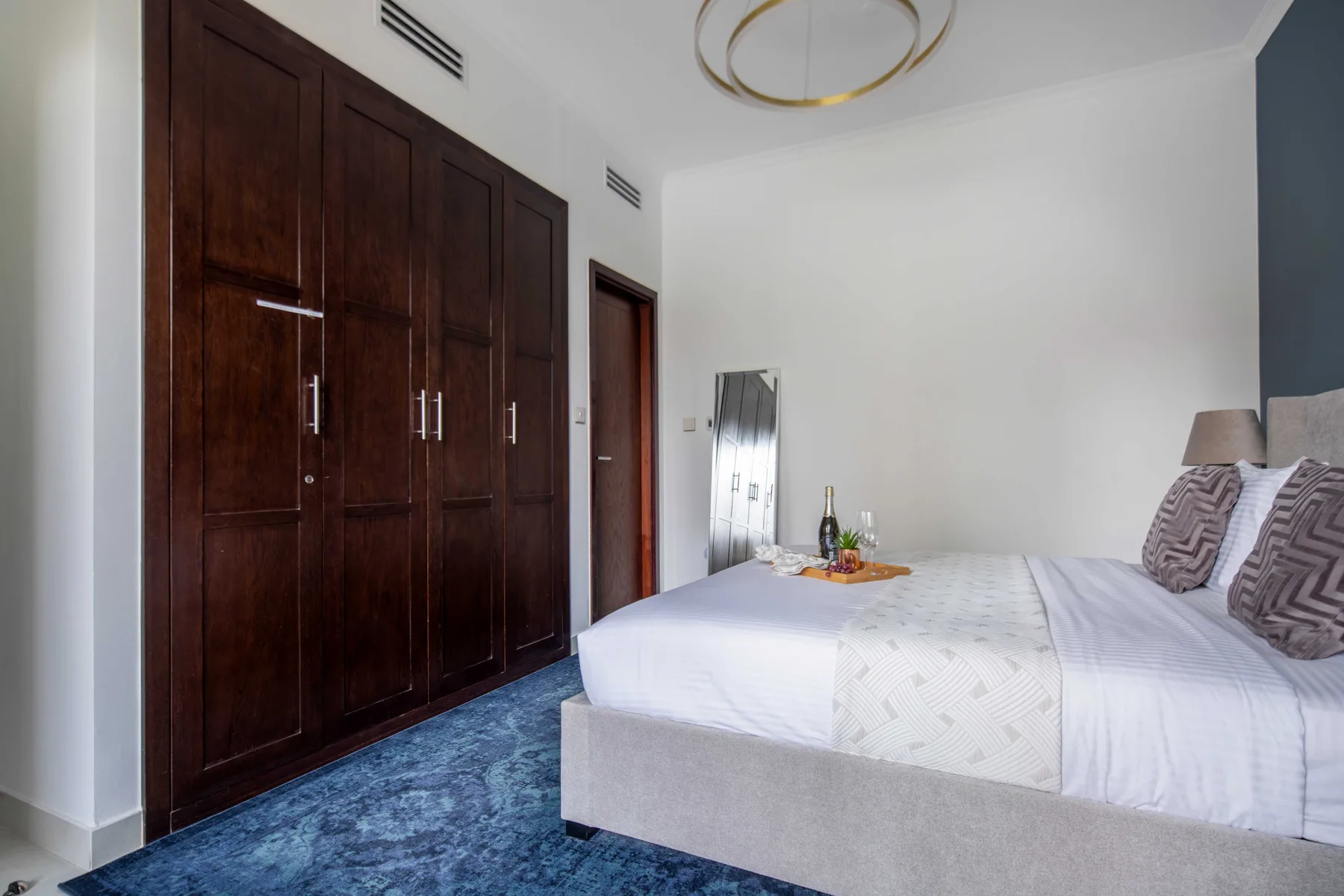 Un dormitorio con una cama grande y armarios empotrados oscuros.