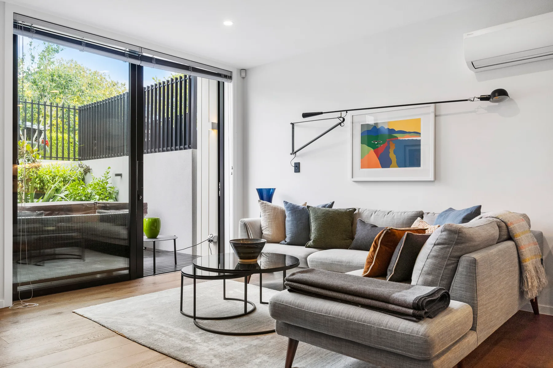 A bright living room with gray seating and a round coffee table.