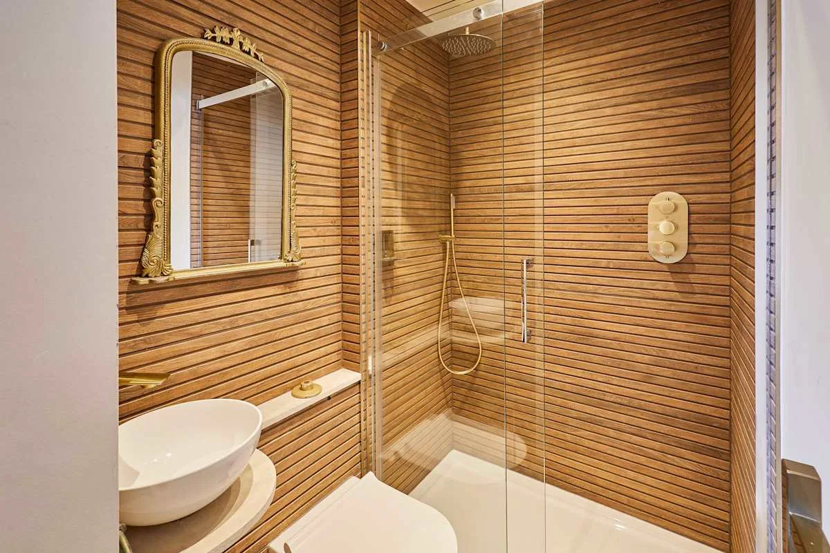 Un baño con ducha de cristal, lavabo e inodoro.