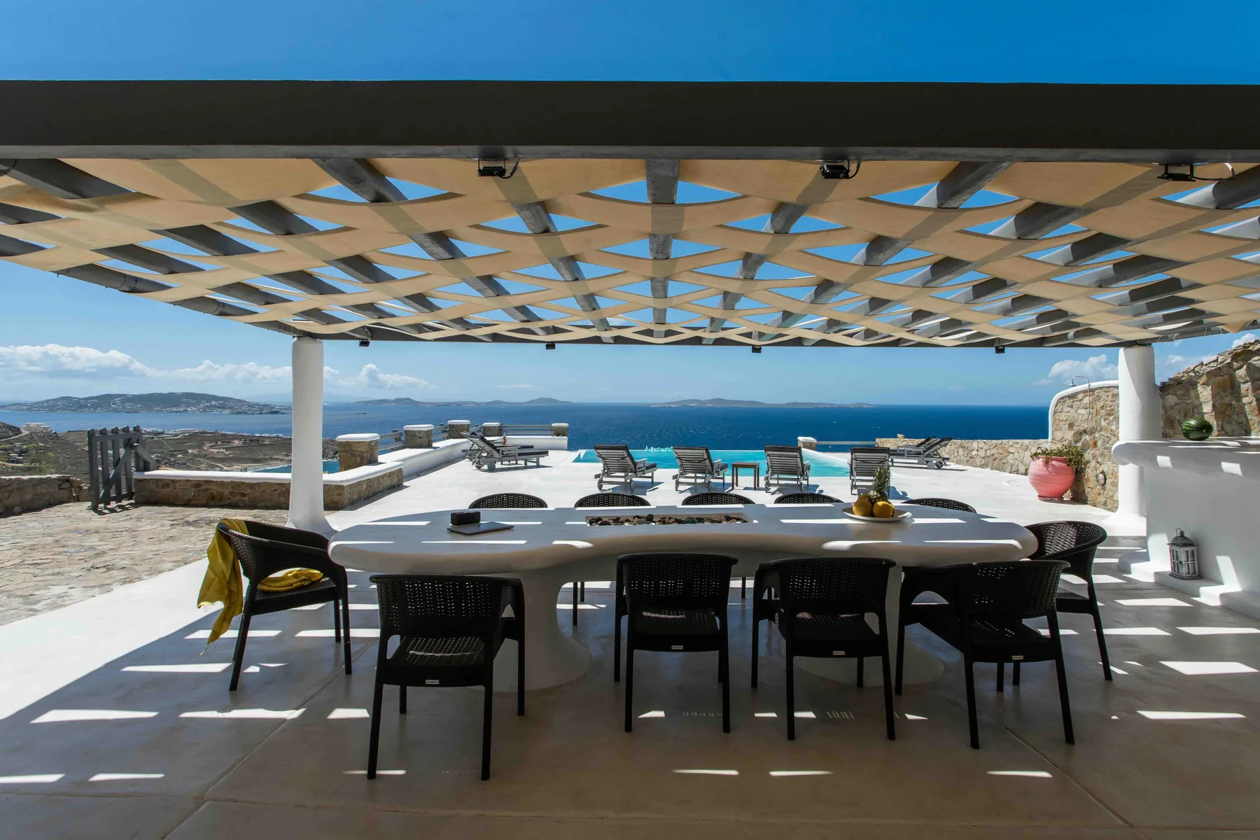 A shaded outdoor dining area overlooks the sea.