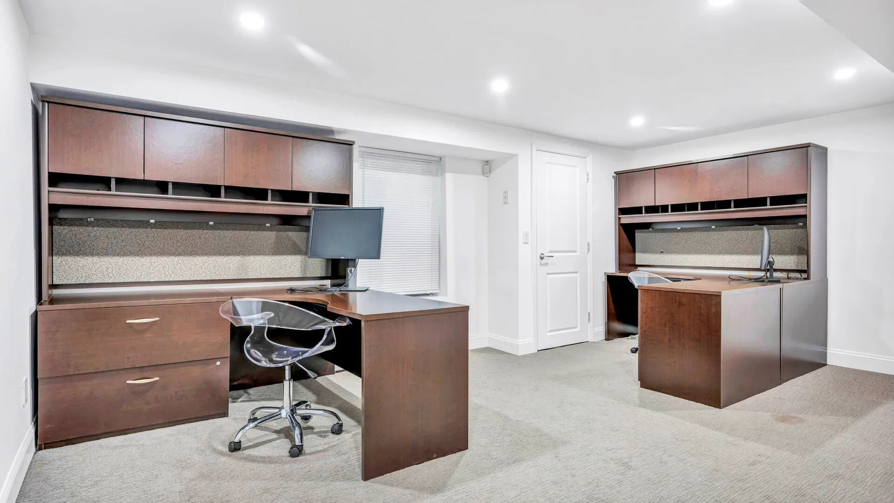 A home office with built-in cabinets, a desk, and a chair.