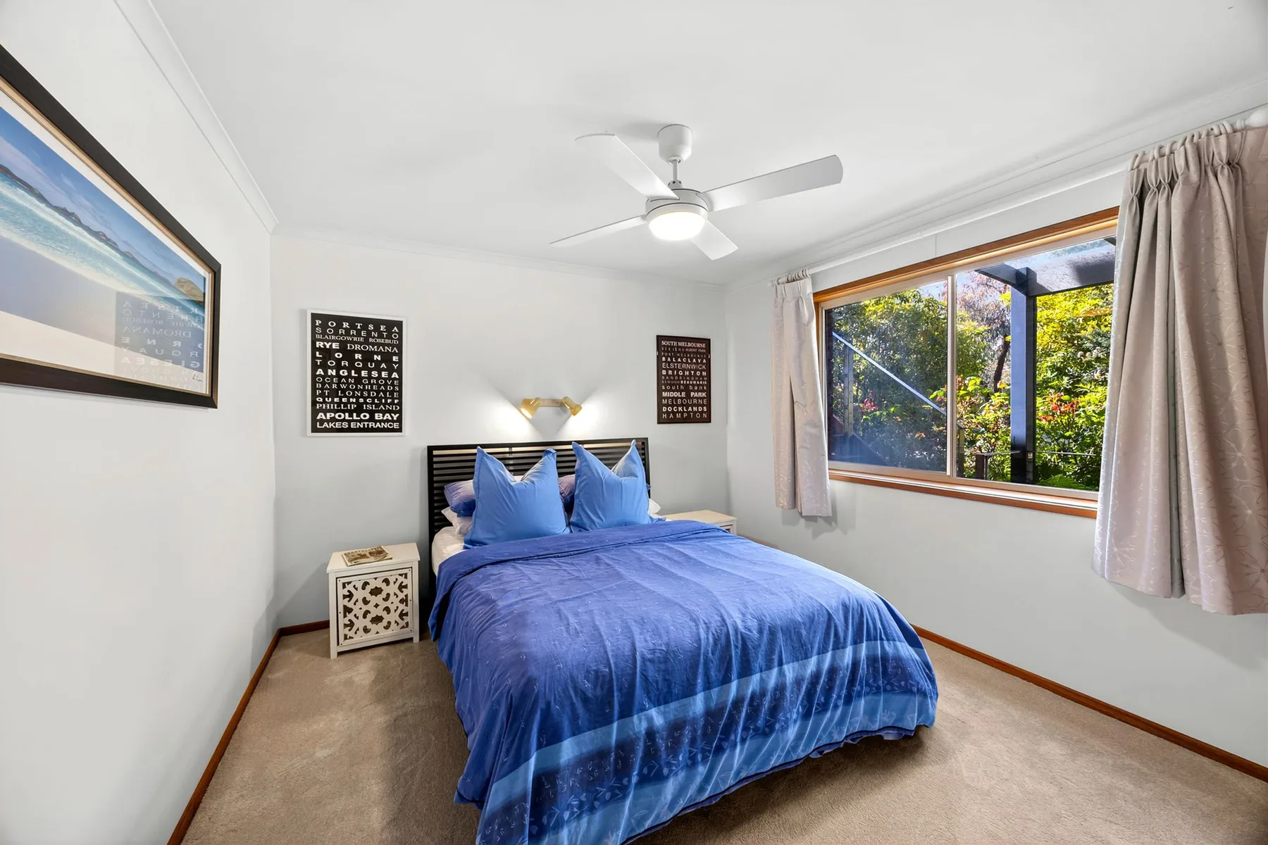 Bedroom with a blue bed and a large window.