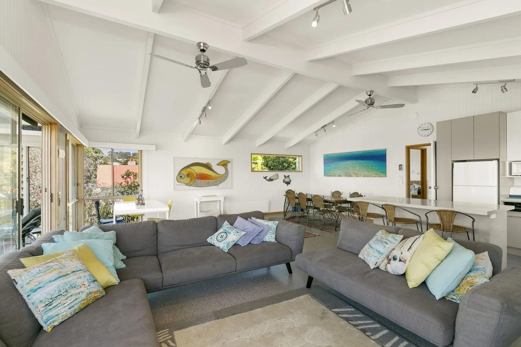 A bright open-plan living and dining area with gray seating.