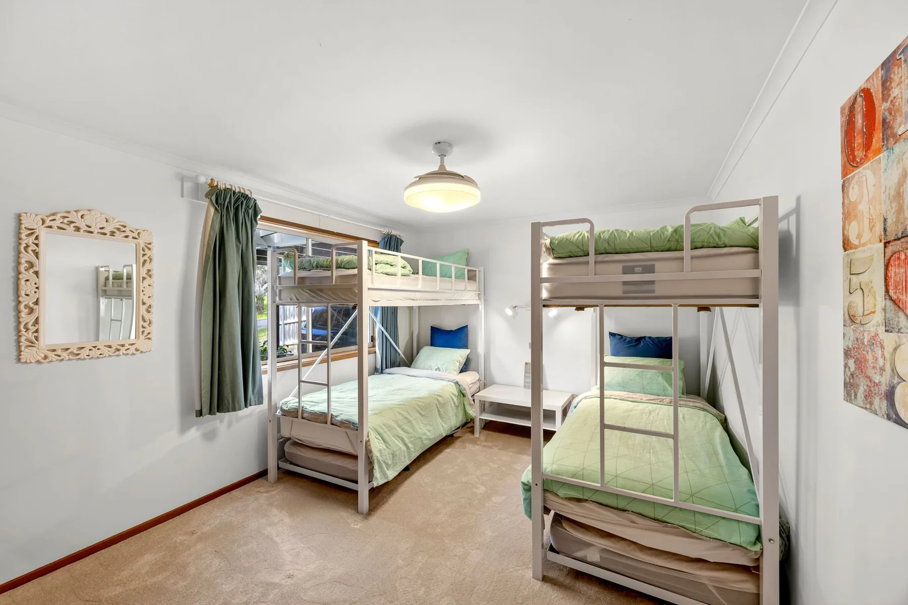 A bright bedroom with bunk beds and green bedding.