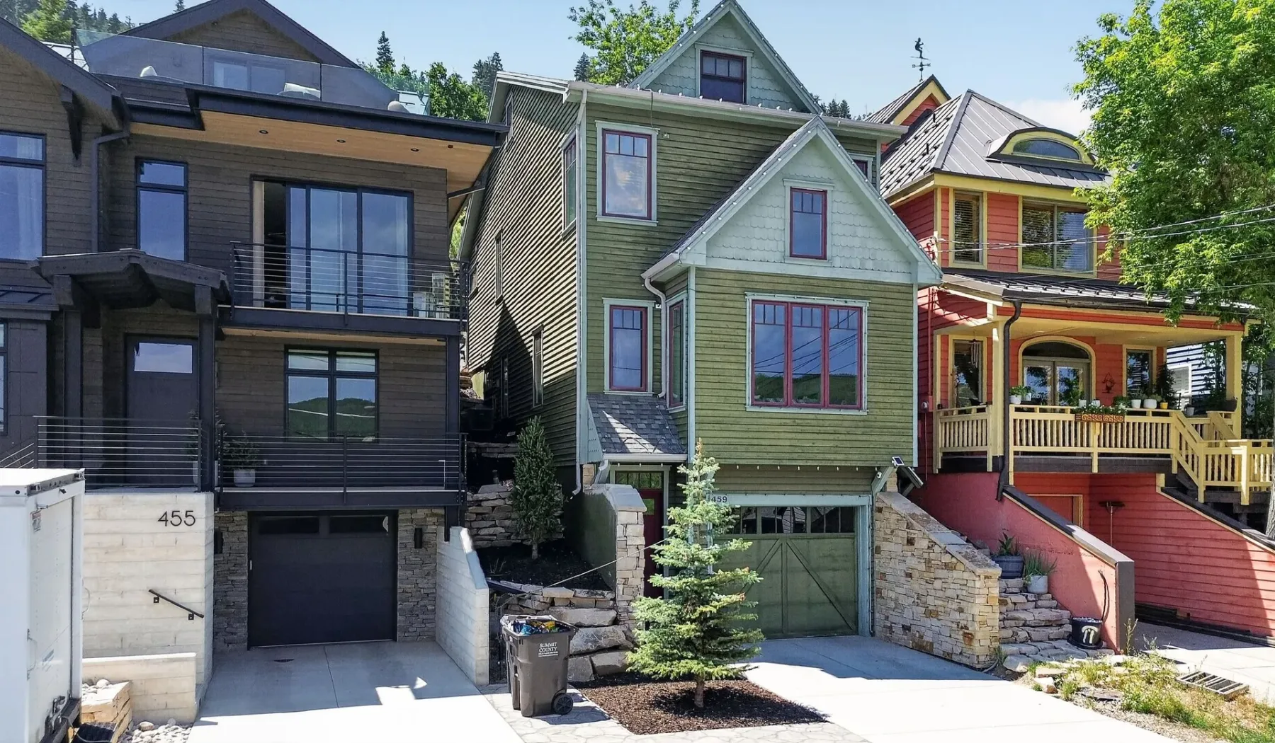 Una hilera de casas coloridas se encuentra junto a una calle pavimentada.