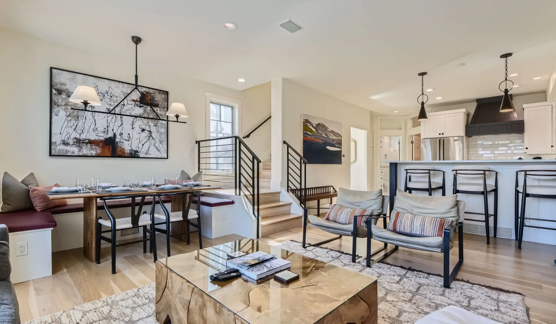 Un espacio abierto de sala y comedor con cocina y escalera.