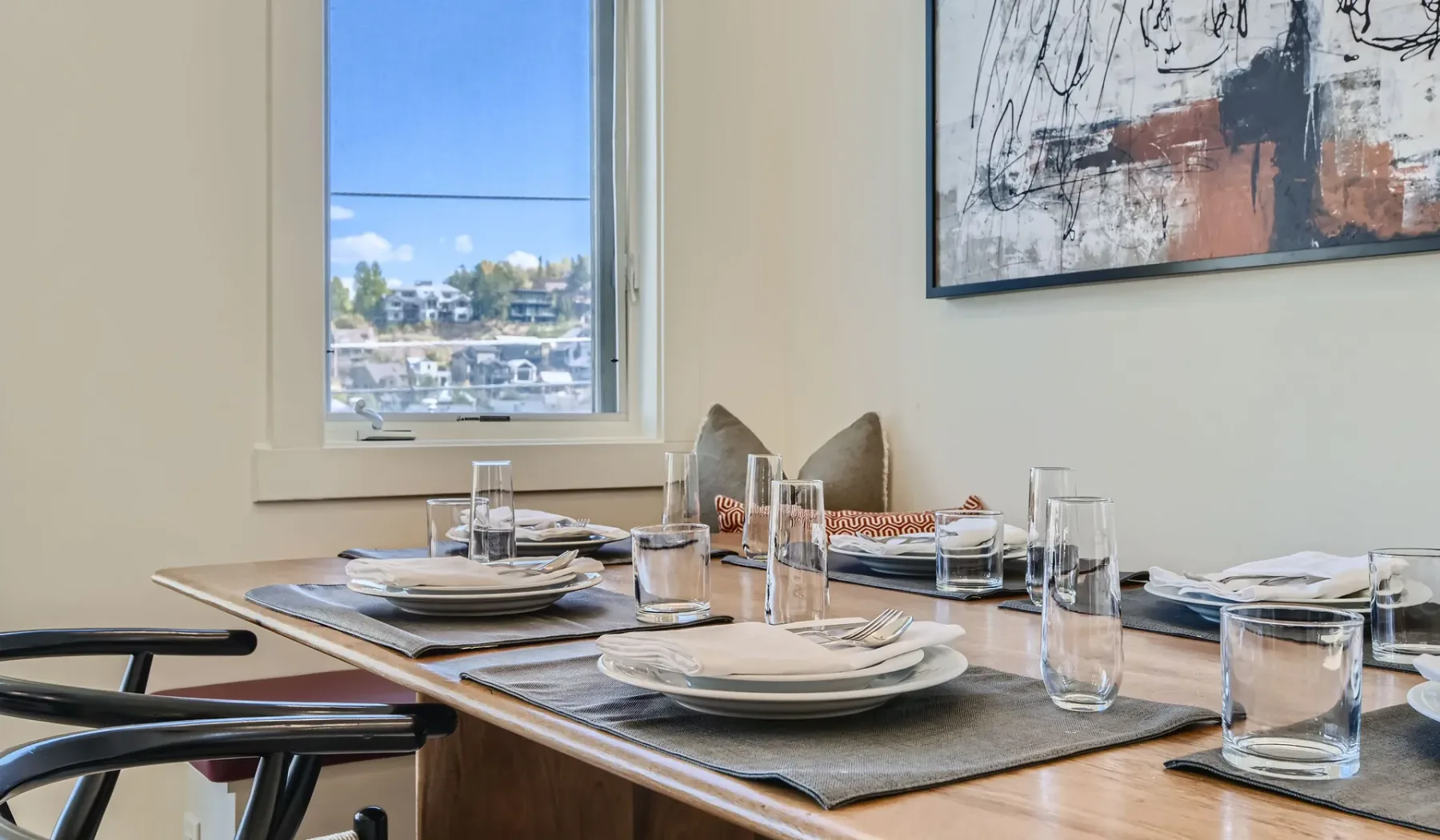 Comedor con una mesa puesta junto a una ventana.