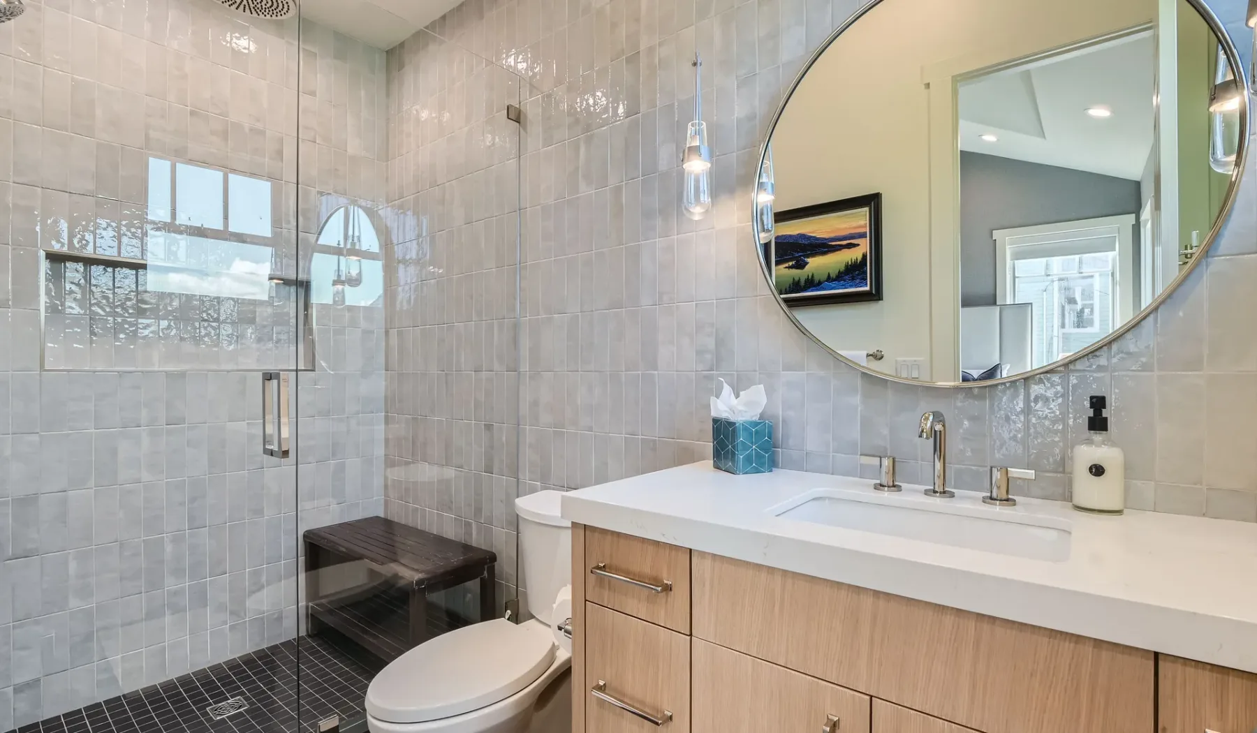 Un baño con azulejos, ducha de vidrio, inodoro y lavabo.