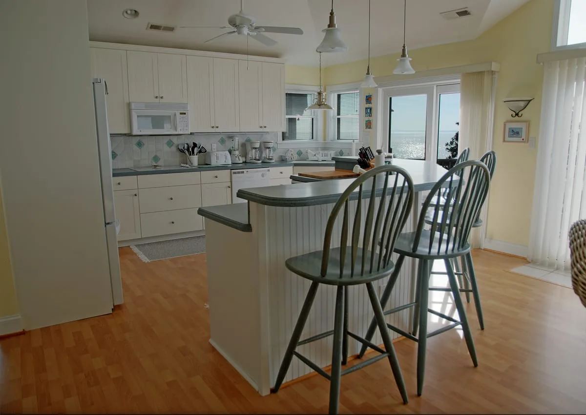 Una cocina luminosa con una isla central y asientos de barra.