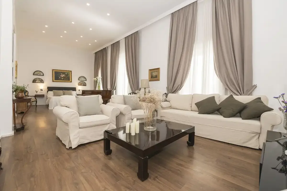 A bright living room with seating arranged around a dark coffee table.