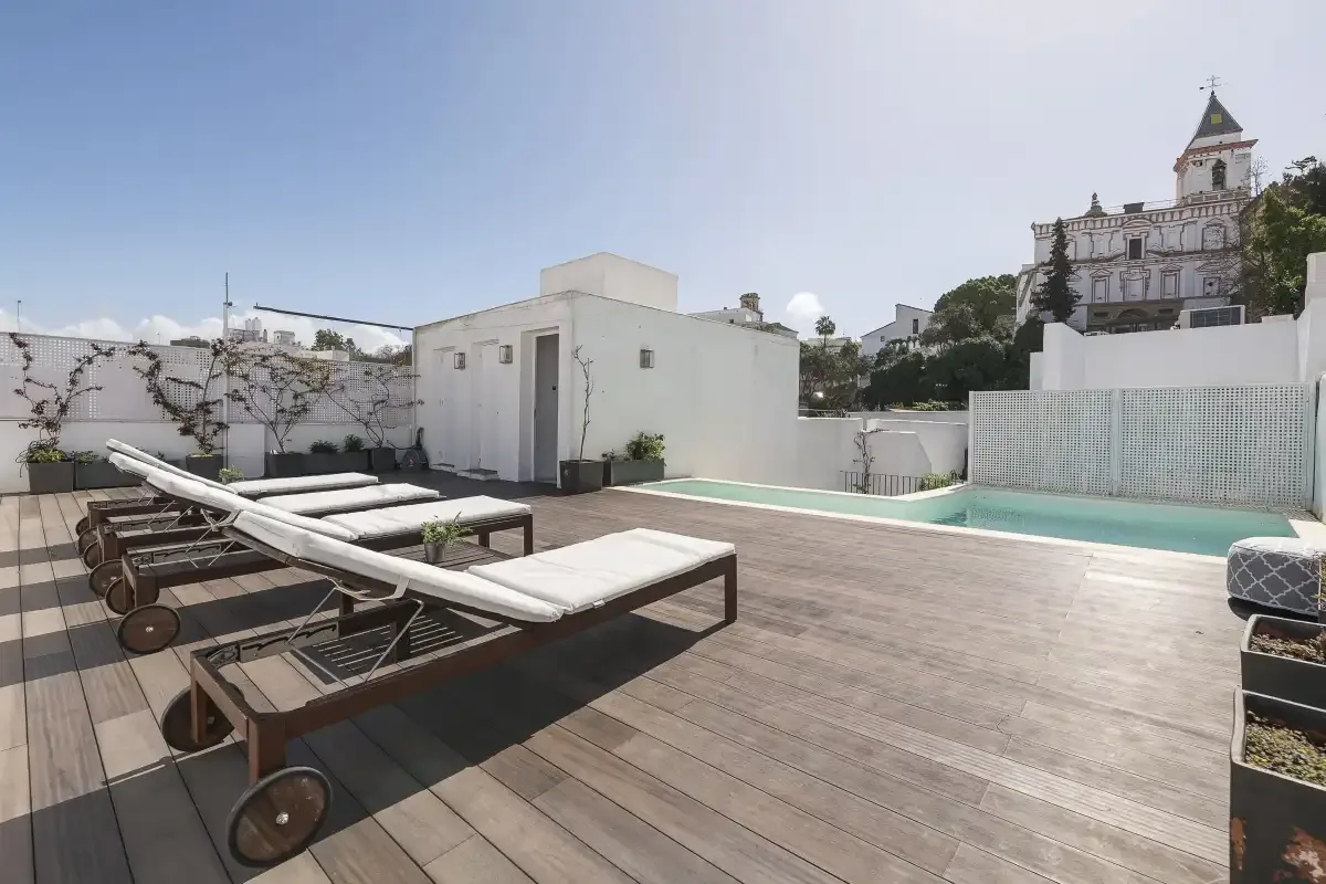 A rooftop terrace with lounge seating and a swimming pool.