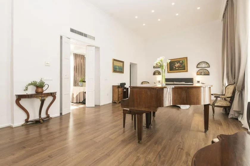 A bright music room with a grand piano and seating.