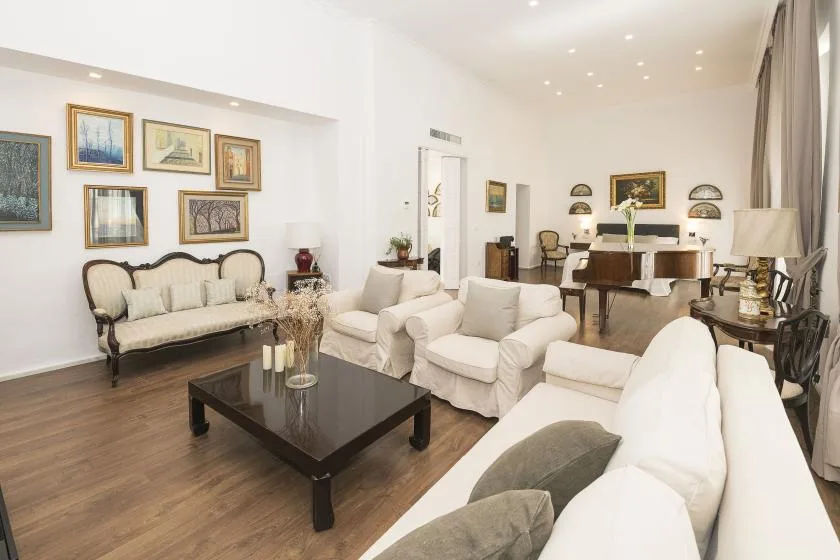 A bright living room with seating, a coffee table, and a dining area.