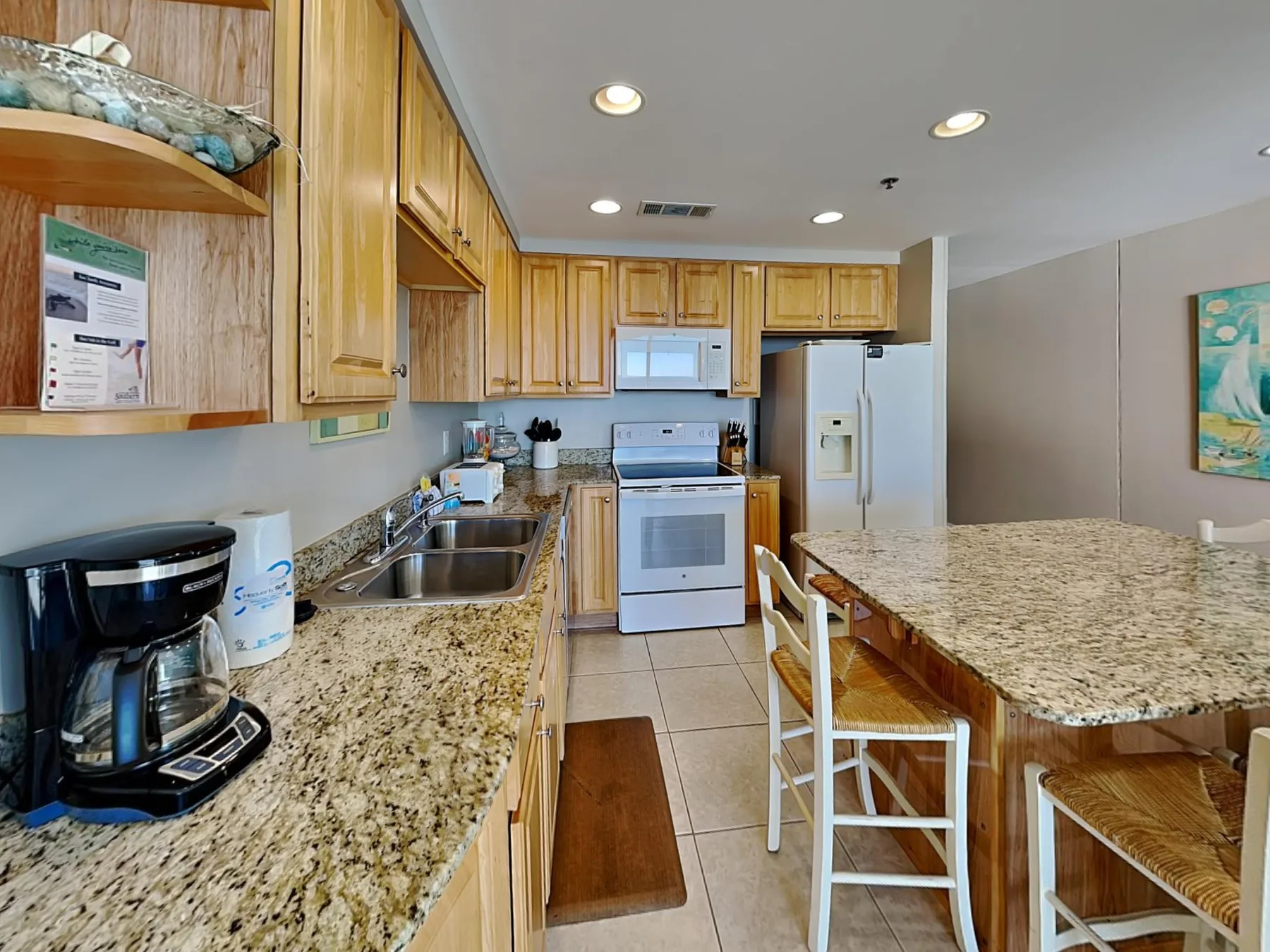A bright kitchen with wooden cabinets, granite counters, and a central island.