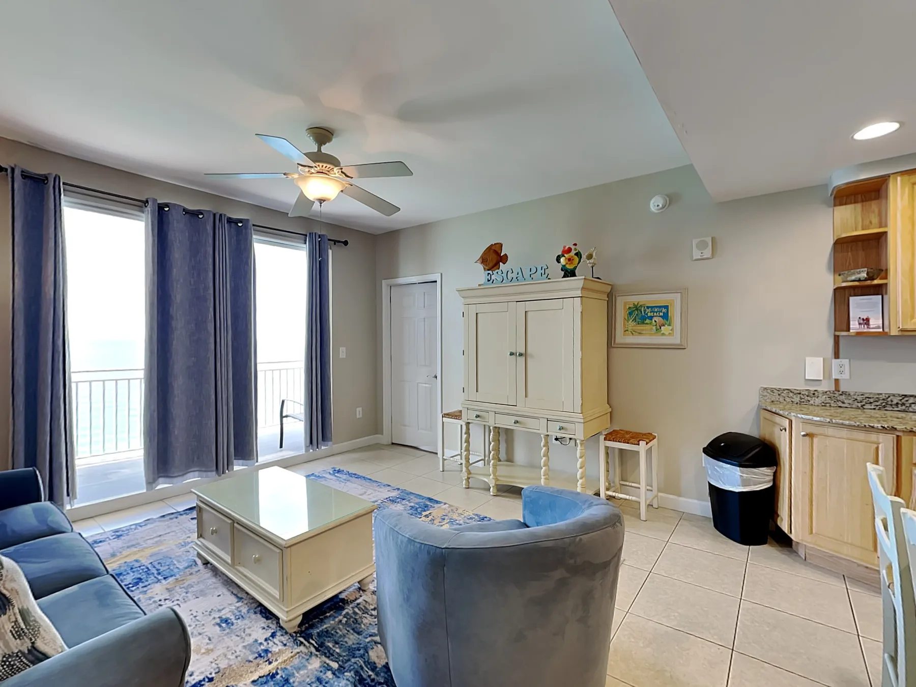 Living room with seating, a coffee table, and a ceiling fan.