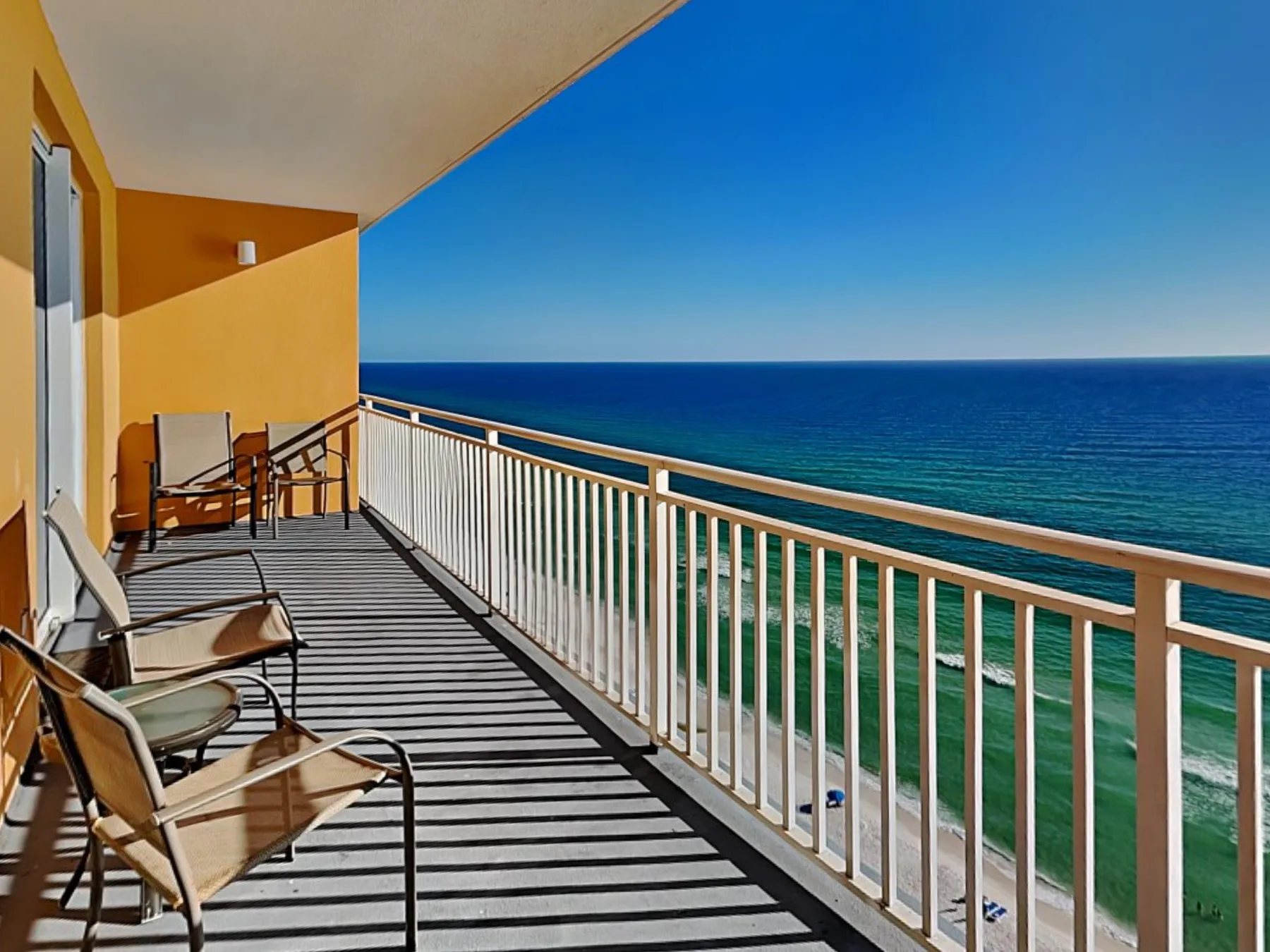 A seaside balcony with seating overlooks the ocean.