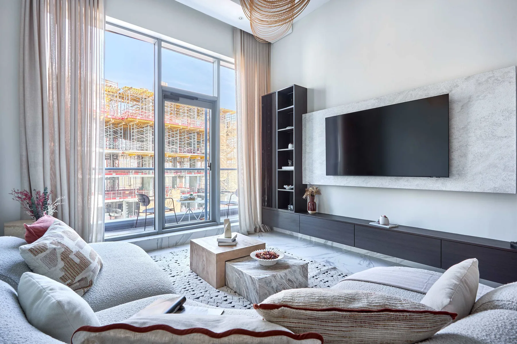 A bright living room with low seating and a wall-mounted television.