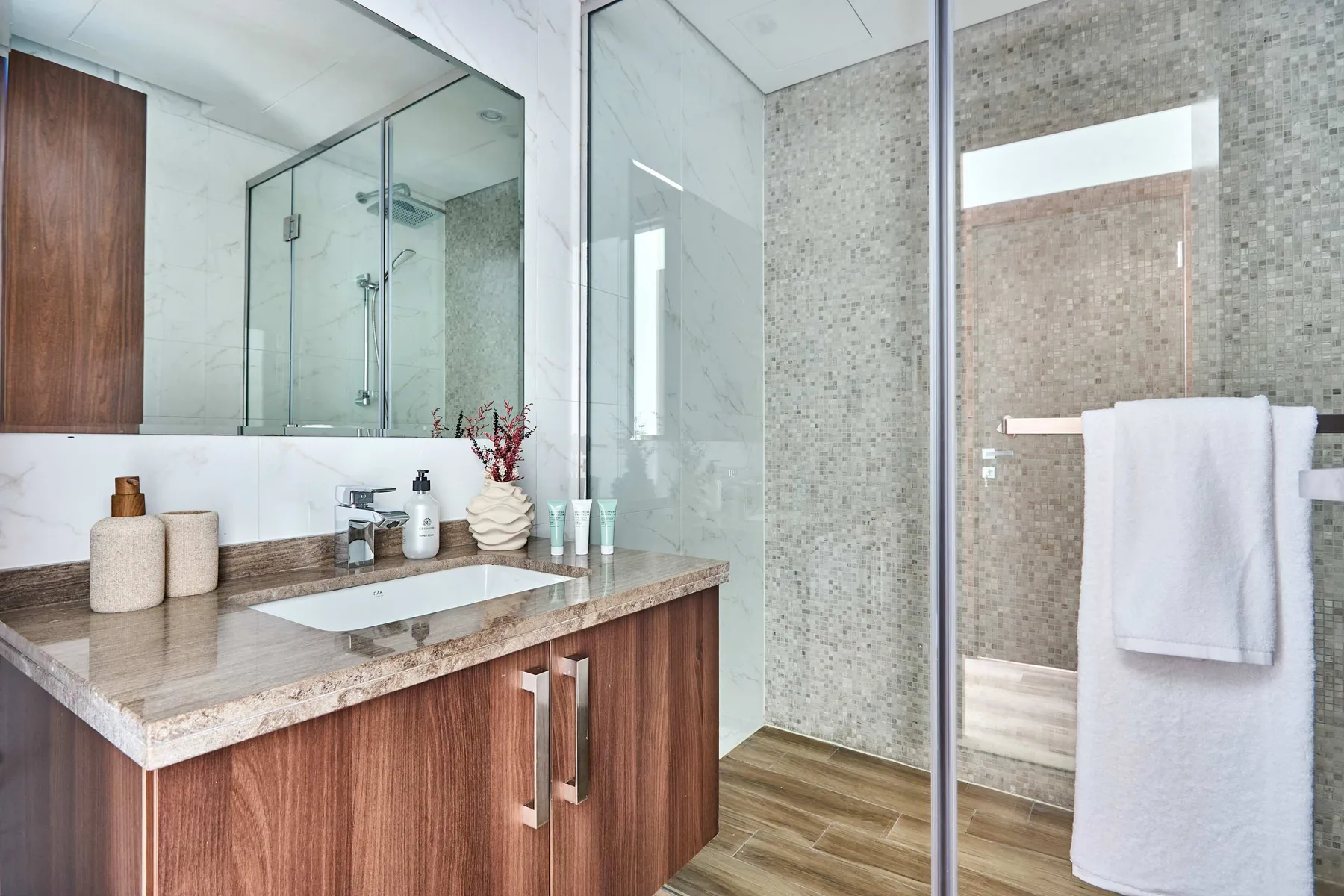 A bathroom vanity with a sink and a glass shower enclosure.