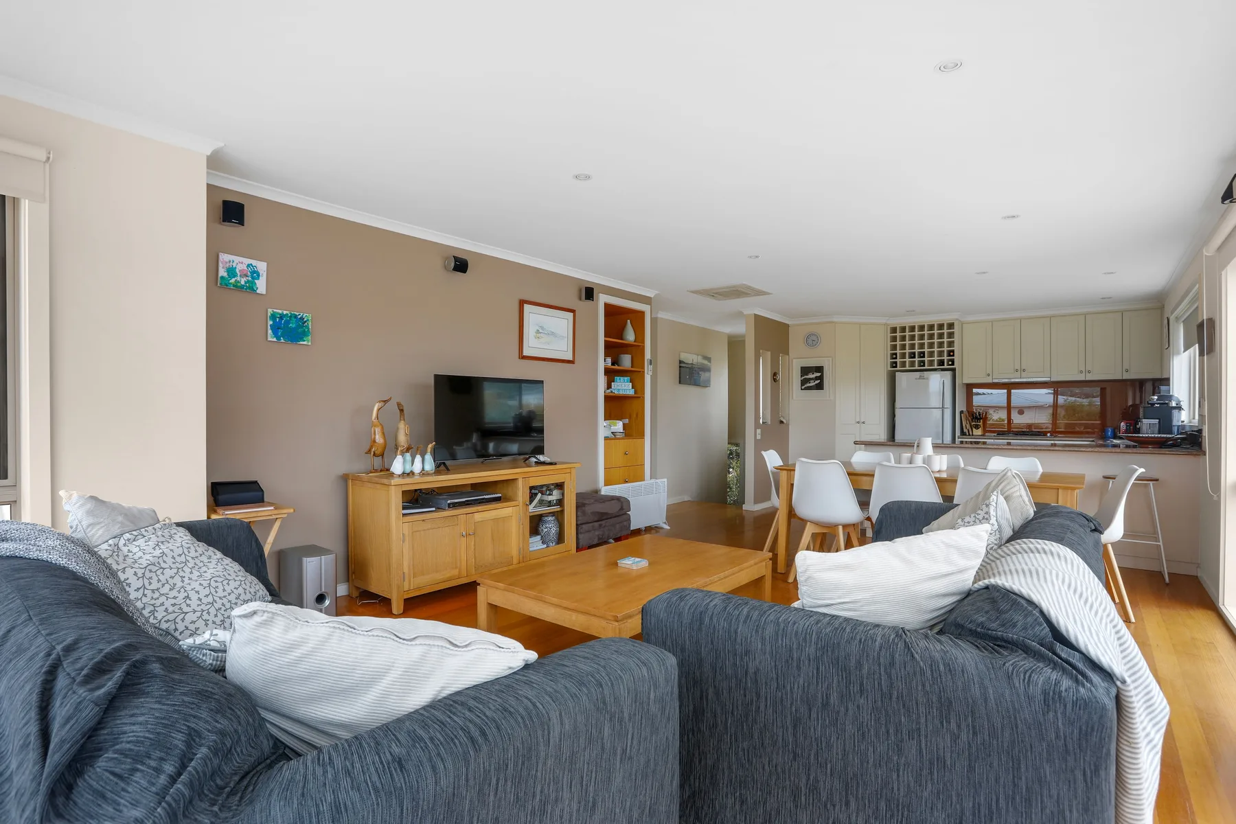 An open-plan living room and kitchen with seating and a dining area.