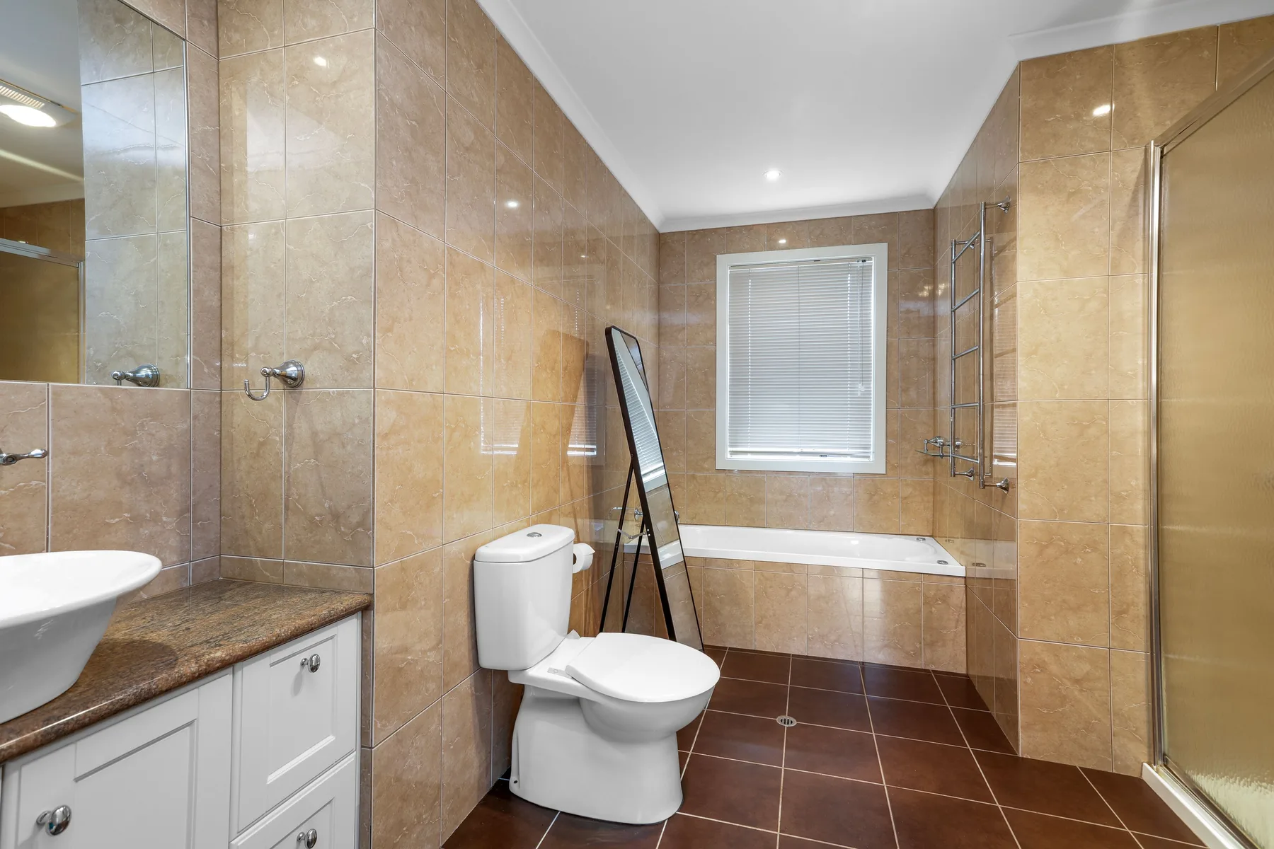 A tiled bathroom with a bathtub, toilet, and sink.
