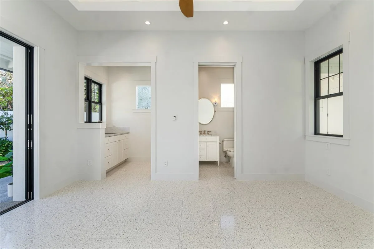 A bright, empty interior room with two open doorways leading to adjacent rooms.