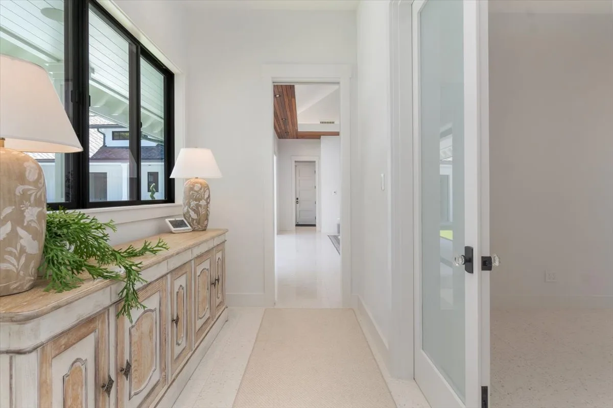 A bright hallway with a long console beneath a large window.