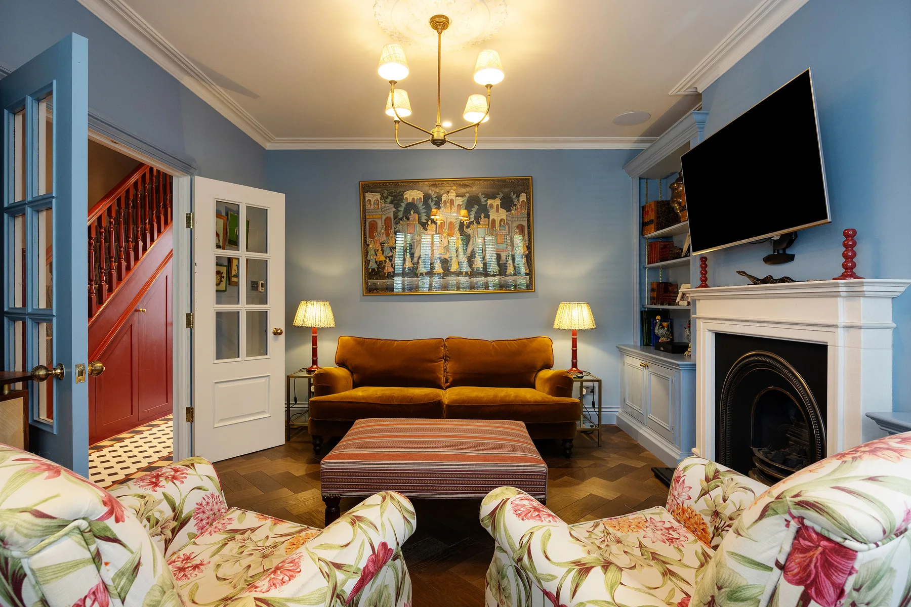 Una sala de estar con paredes azules, un sofá y una chimenea.