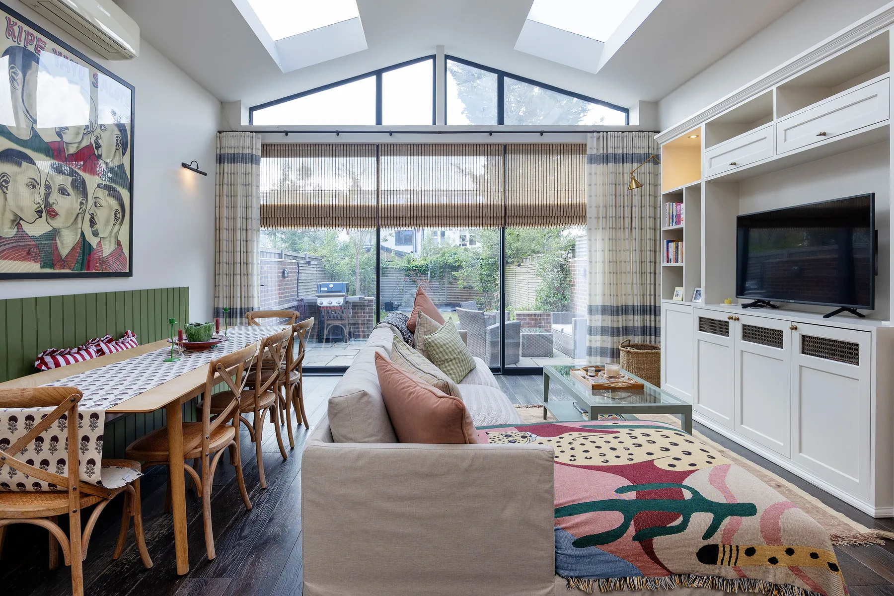 Una luminosa sala de estar con mesa de comedor y asientos junto a grandes ventanas.